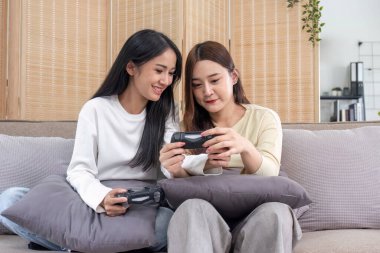 Genç Asyalı çift evde video oyunu oynuyor oturma odasında eğleniyorlar...