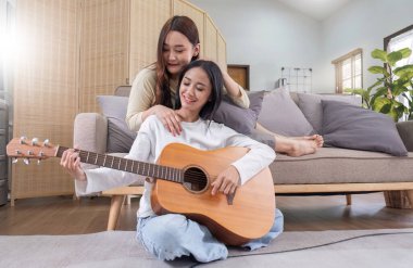 LGBT. İki genç kadın gitar çalıyor ve birlikte salonda şarkı söylüyorlar...