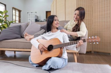 LGBT. İki genç kadın gitar çalıyor ve birlikte salonda şarkı söylüyorlar...