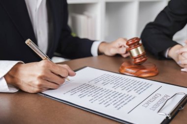 İş adamı ve avukat avukatlık bürosunda yasal danışmanlık için iş sözleşmesi belgelerini tartışıyorlar..