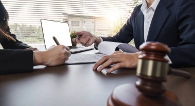 İş adamı ve avukat avukatlık bürosunda yasal danışmanlık için iş sözleşmesi belgelerini tartışıyorlar..