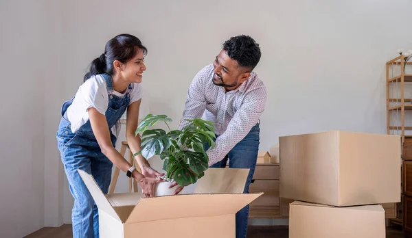 A couple moves into a new house. happily holding boxes and moving things together..