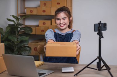 KOBİ işletme sahibi bir çevrimiçi işletme için mal teslimatını gösteren bir paket kutusu tutuyor..