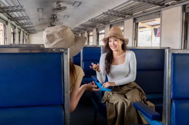 Genç bayan turistler trende otururken sohbet ediyorlar...