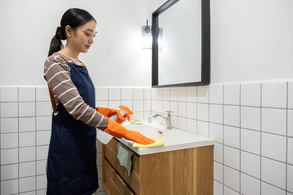 Genç Bir Hizmetçi Bez Temizlik Spreyi Kullanarak Banyoyu Temizliyor — Stok fotoğraf
