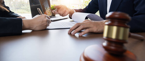 Businessman and lawyer discussing business contract document for legal advice in lawyers office..