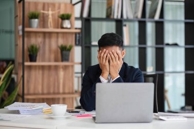 Genç mutsuz ofis çalışanı işte sıkılmış hissediyor. Ofiste çalışırken yüzü dağılmış dizüstü bilgisayara bakıyor. Dikkati dağılmış bir erkek işçi monoton bir işten bıkıp usanmış hissediyor..