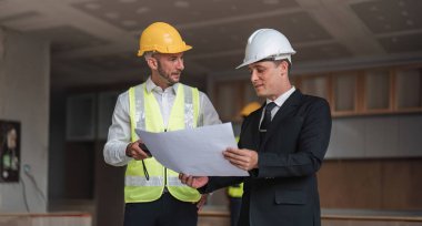 Diverse Team of Specialists Use Laptop on Construction Site. Real Estate Building Project with Engineer Investor and Businessman Checking Area, working on Civil Engineering, Discussing Strategy Plan.