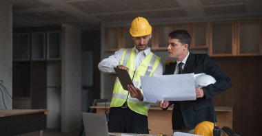 Diverse Team of Specialists Use Laptop on Construction Site. Real Estate Building Project with Engineer Investor and Businessman Checking Area, working on Civil Engineering, Discussing Strategy Plan.