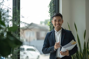 İş belgelerine sahip genç bir işadamının portresi başarılı bir iş adamı iş belgelerini yönetiyor...