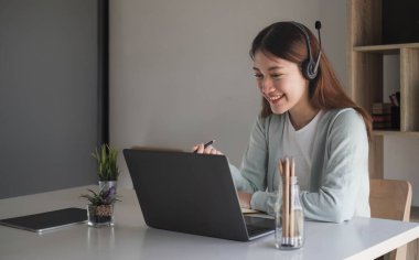 Asyalı kız öğrenci çevrimiçi öğrenme dersi çevrimiçi video öğretmeni, Mutlu Asyalı kız bilgisayar laptopuyla İngilizce öğreniyor.