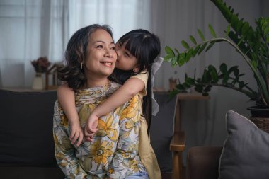 Büyükannen ve torunun oturma odasında birlikte oturup oyun oynarlar...