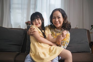 Büyükannen ve torunun oturma odasında birlikte oturup oyun oynarlar...