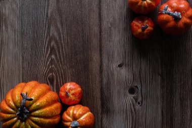 Cadılar Bayramı konsepti. Balkabağı dekorasyonu ve tahta zeminde uçan siyah kağıt yarasa...