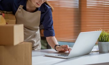 KOBİ girişimcileri paket kutusunun önüne bilgi yazıp sırayı ve sırayı kontrol ederler. Paketleri teslimat için hazırlayın...