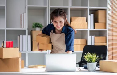 KOBİ girişimcileri paket kutusunun önüne bilgi yazıp sırayı ve sırayı kontrol ederler. Paketleri teslimat için hazırlayın...