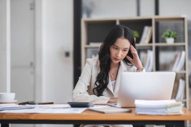 Şaşkın şaşkın Asyalı kadın fazla düşünüp dizüstü bilgisayar ekranına bakarak online sorun çözüm endişe, zor iş bilgisayar görevi çözme odaklı ciddi Asya işkadını endişeli.
