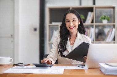 İş kadını, ofis ve iş geçmişinde, vergi, muhasebe, istatistik ve analitik araştırma kavramında matematik finansmanı için hesap makinesi kullanıyor...