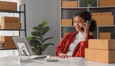 Küçük bir KOBİ girişimcisi işi bir tablet aracılığıyla iletir ve bir ofiste kutularca mal teslim etmeye hazır mallarla konuşur..