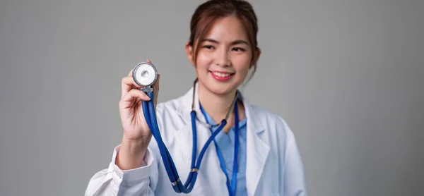 女性医師の肖像画は 平らな背景にステスコープを使用しています 医療コンセプト 女性医師 患者さんの健康をチェックするための設備 — ストック写真