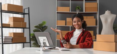 Küçük bir KOBİ girişimcisi işi bir tablet aracılığıyla iletir ve bir ofiste kutularca mal teslim etmeye hazır mallarla konuşur..