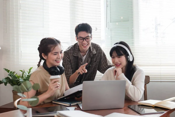 stock image A cheerful and intelligent young Asian man is standing and sharing his thoughts in a meeting with his team. University students, friendship, startups, teamwork.