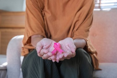 Yakın plan kadın elinde pembe kurdele sembolü var. Göğüs kanseri farkındalığı ve Ekim pembe günü, dünya kanseri günü, ulusal kanser kurtulanlar günü. sağlık hizmeti kavramı.