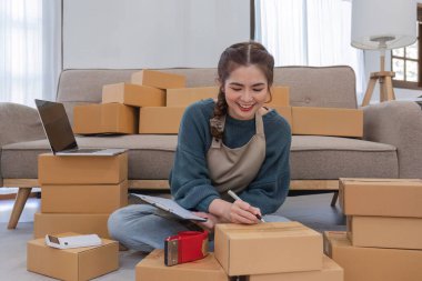 Küçük işletme girişimcisi KME, kutuda kumaş paketleyen Asyalı kadın. Portre genç Asyalı küçük işletme sahibi ev sahibi, çevrimiçi satış pazarlama teslimatı, KME e-ticaret tele pazarlama kavramı.