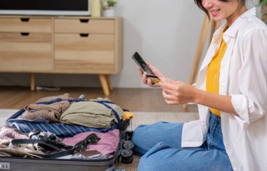 Genç Asyalı mutlu bir kadın telefon başvurusu ile bilet ya da konaklama ayarlar ve kredi kartıyla öder. Hafta sonu gezisine çıkmadan önce..