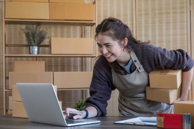 Küçük işletme girişimcisi KME, kutuda kumaş paketleyen Asyalı kadın. Portre genç Asyalı küçük işletme sahibi ev sahibi, çevrimiçi satış pazarlama teslimatı, KME e-ticaret tele pazarlama kavramı.