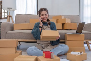 Küçük işletme sahipleri iş yerinde telefon kullanıyor, satış elemanları üretim siparişlerini kontrol ediyor. Ürünleri müşterilere yollamak, nakliye fikirleri satmak için paketleyin..