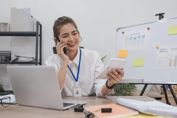 Young businesswoman uses the phone to talk with customers in business planning, business management..