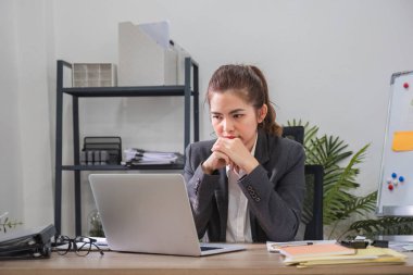 Kafası karışmış Asyalı kadın laptop ekran sorununu nasıl çözeceği konusunda ciddi şekilde stresli. Ciddi Asyalı iş kadını zor bilgisayar görevlerini çözmeye odaklanmış..