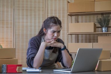 Küçük işletmeler, Girişim KOBİ, Girişimciler. İnternetten alışveriş yapan Asyalı bir kadın ağlıyor ve mutsuz bir yüz ifadesi takınıyor...