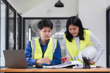 İnşaat mühendislerinden oluşan bir ekip inşaat alanındaki bir ofiste çalışıyor ve radyo aracılığıyla çalışmayı kontrol ediyor...