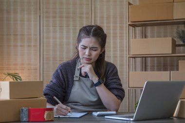 Küçük işletmeler, Girişim KOBİ, Girişimciler. İnternetten alışveriş yapan Asyalı bir kadın ağlıyor ve mutsuz bir yüz ifadesi takınıyor...