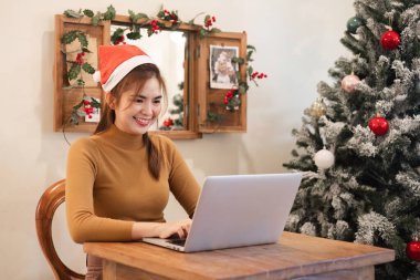 Yeni başlayan bir çalışan Noel arifesinde dizüstü bilgisayara rapor yazar. Noel tatili boyunca renkli ampullerle süslenmiş bir ofiste..
