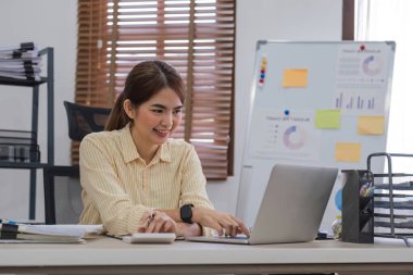 Hesap makinesi ve dizüstü bilgisayar kullanan iş kadını ofis ve iş geçmişinde, vergi, muhasebe, istatistik ve analitik araştırma kavramında ahşap masada finans yapıyor..