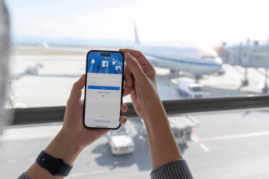 CHIANG MAI, THAILAND - 5 DEC 2023: Yeni giriş ekranlı facebook kullanmak için iPhone 14 'ü elinde tutan kadın. Facebook dünyanın en büyük sosyal ağı ve en popüler sosyal ağ sitesidir...