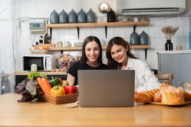 İki iş kadını iş yerinde birlikte çalışıyor. İnternette çalışma konusundaki fikirlerinizi paylaşın...