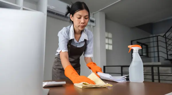 Young woman cleaning to disinfect computer and equipment on office table Cleaning staff or maid cleaning the office.