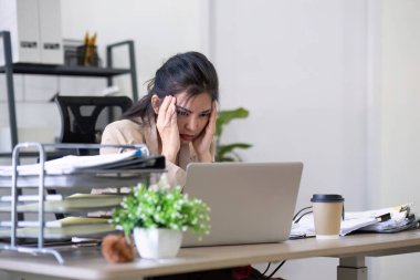 Şaşkın şaşkın Asyalı kadın fazla düşünüp dizüstü bilgisayar ekranına bakarak online sorun çözüm endişe, zor iş bilgisayar görevi çözme odaklı ciddi Asya işkadını endişeli.