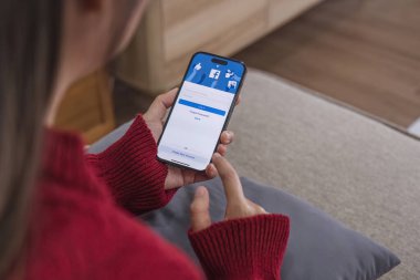 CHIANG MAI, THAILAND - 3 HAZİRAN 2024: İphone 14 'ü elinde tutan kadın Facebook uygulaması ile ekranda. Facebook popüler bir online sosyal ağ hizmetidir..