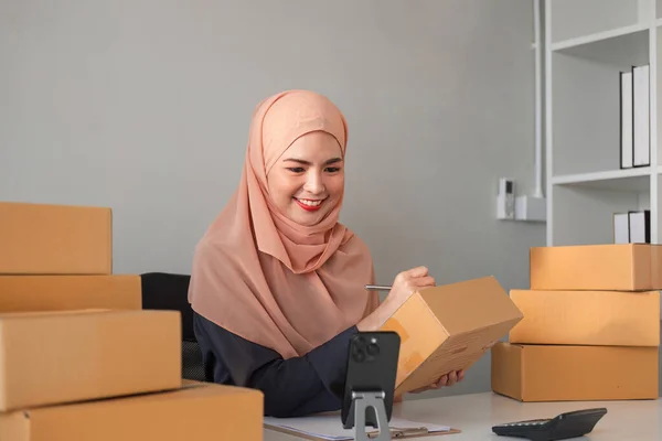 Beautiful Muslim woman selling online at home, business owner, business start up small business concepts.