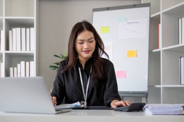 Hesap makinesi ve dizüstü bilgisayar kullanan iş kadını ofis ve iş geçmişinde, vergi, muhasebe, istatistik ve analitik araştırma kavramında ahşap masada finans yapıyor..