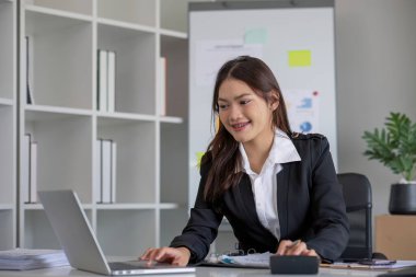 Hesap makinesi ve dizüstü bilgisayar kullanan iş kadını ofis ve iş geçmişinde, vergi, muhasebe, istatistik ve analitik araştırma kavramında ahşap masada finans yapıyor..