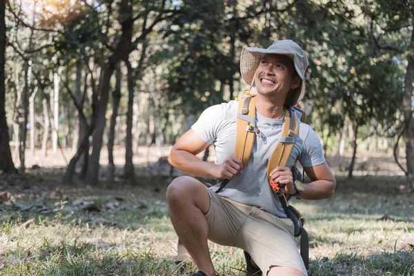 Portrait of a happy smiling Asian tourist, 30-35 years old, backpacking in a national park. asian male tourist enjoying his hiking trip Nature activities, holidays, outdoor hobbies..
