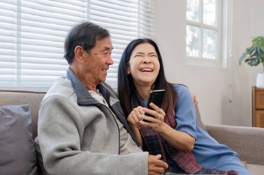 60 'lı yaşlarda yaşlı bir çift boş zamanlarını oturma odasındaki kanepede birlikte eğlenerek geçirir...