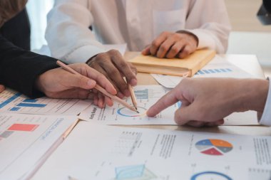 Asyalı iş adamları beyin fırtınası yaptılar ve iş planlarını tartıştılar. Konferans odasındaki şirketin mali veya istatistiksel rakamları.