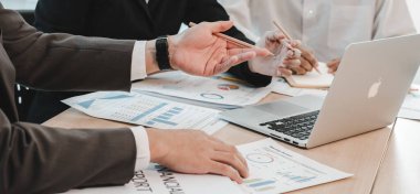 Asyalı iş adamları beyin fırtınası yaptılar ve iş planlarını tartıştılar. Konferans odasındaki şirketin mali veya istatistiksel rakamları.